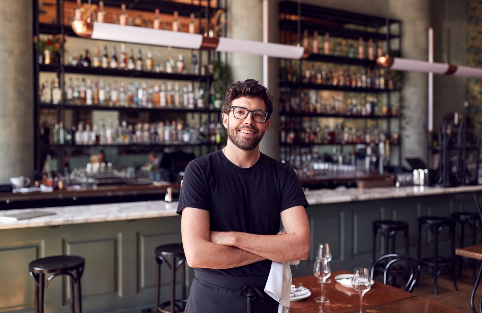 Portrait Of Male Waiter Standing In Bar Restaurant Before Service